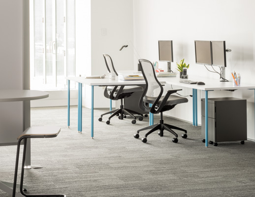 Knoll Antenna Simple tables with blue legs for primary workstations